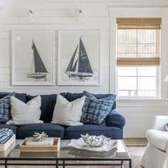 a living room with blue couches and pictures on the wall above them, along with other furniture