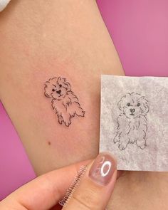 a small dog tattoo on the side of a woman's right thigh, next to a piece of paper