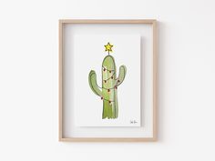 a painting of a cactus in a wooden frame on the wall with a star above it