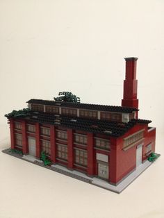 a model of a red building with a chimney on the top and two stories above it