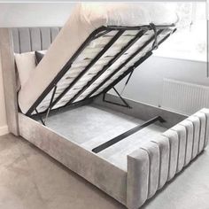 a bed with a mattress attached to it and the bottom half opened up in front of a window