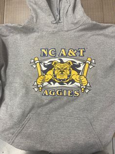 100% licensed North Carolina A&T hoodie. Hooded Tops For Fan Merchandise, Fan Merchandise Drawstring Hood Top, Fall Sports Event Hoodie With Logo Print, Collegiate Hoodie For Sports Season, Fleece Hoodie With Logo Print For Sports Season, Fleece Fan Apparel Sweatshirt, Fall Fan Gear Hoodie With Graphic Print, Fleece Hoodie For Fan Gear, Fall Graphic Print Hoodie For Fan Gear