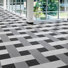 a black and white checkered floor in an office building with glass doors on both sides