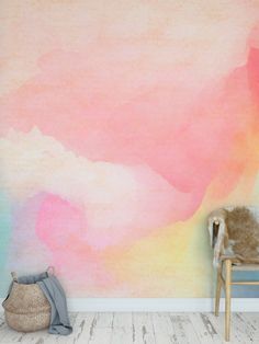 a chair sitting in front of a wall painted with pastel colors and watercolors