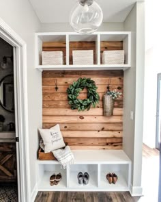 an instagram photo of a room with shelves, shoes and wreath on the wall