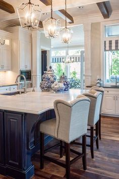 a large kitchen with an island and chandelier hanging from it's ceiling