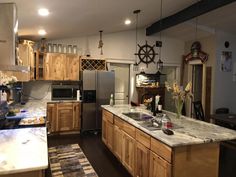 a kitchen filled with lots of wooden cabinets and counter top next to a refrigerator freezer