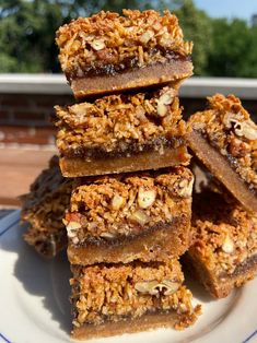 a stack of granola bars sitting on top of a white plate next to a window