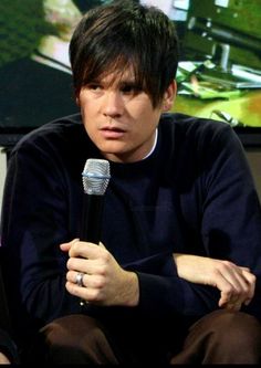 a man holding a microphone while sitting down