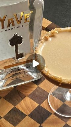 a pie sitting on top of a wooden table next to a bottle of yave