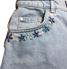 a pair of jeans with embroidered flowers on them