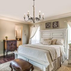 a large white bed sitting in a bedroom on top of a hard wood floor