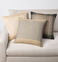 three pillows sitting on top of a couch