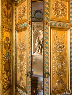 an ornately decorated room with gold and blue paint on the walls, doors and ceiling