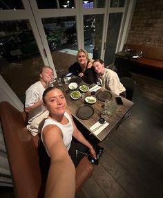 four people sitting at a table with plates of food