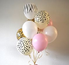 a bunch of balloons with zebra print and pink, white and black dots on them