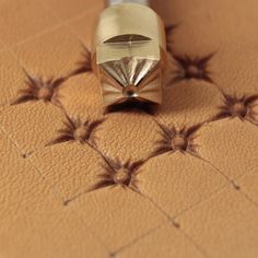 a close up of a metal object on a tile floor with small stars around it