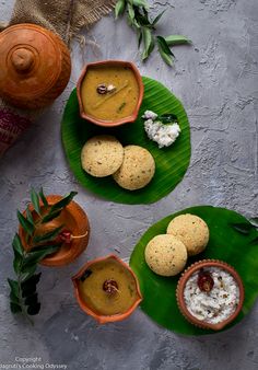 three plates filled with food on top of a green leafy plate next to a potted plant