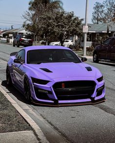 a purple sports car is parked on the street