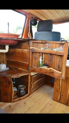 the inside of a wooden vehicle with shelves and drawers on it's side wall