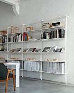 a chair sitting in front of a book shelf filled with books