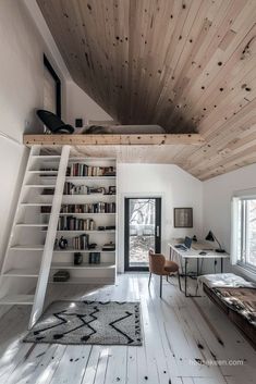 a room with white walls and wooden ceilinging, bookshelves on the wall