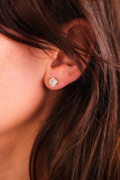 a close up view of a woman's ear wearing a diamond studded earrings