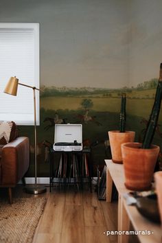 a living room filled with furniture and a painting on the wall next to a window