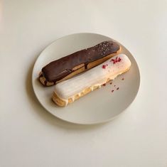 a white plate topped with an ice cream sandwich and a chocolate frosted donut