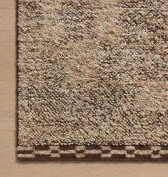 an area rug with brown and beige colors on the floor, including one square in the middle