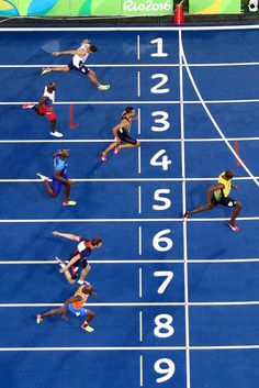 the athletes are competing in a race on the blue track at the olympic games,