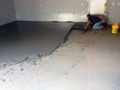 a man is laying concrete on the floor