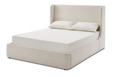 a bed with a white headboard and pillows on it's sides, in front of a gray background