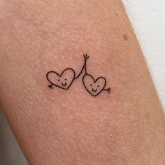 two heart shaped tattoos on the back of a woman's arm