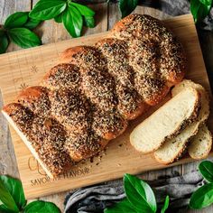 sliced loaf of bread with sesame sprinkled on top sitting on a cutting board