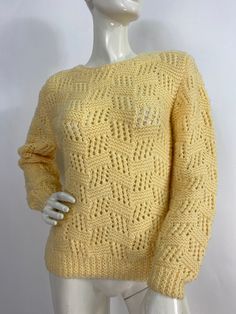 a white mannequin wearing a yellow sweater on a white background with an openwork pattern