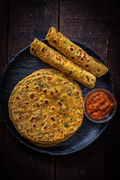 an omelet and two pieces of bread on a plate with dipping sauces