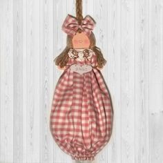 a doll hanging from a rope on a white wooden wall with wood planks in the background