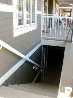 stairs leading up to the front door of a house with white railings and windows