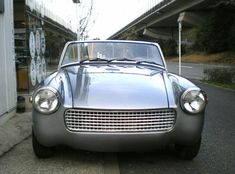 an old car is parked on the side of the road