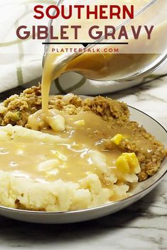 a plate with mashed potatoes and gravy being poured over it to make a southern dish