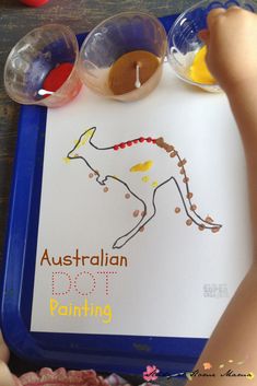 a child's hand is holding an australian dot counting game in front of the children's hands