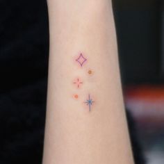 a woman's wrist with three small stars on the left side of her arm