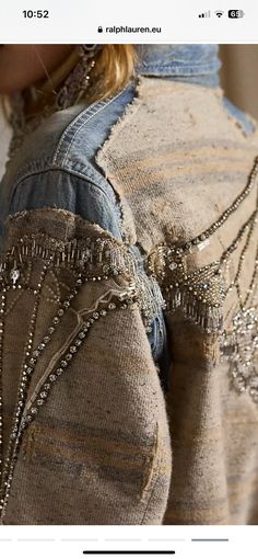 the back of a woman's jean jacket with beading and buttons on it