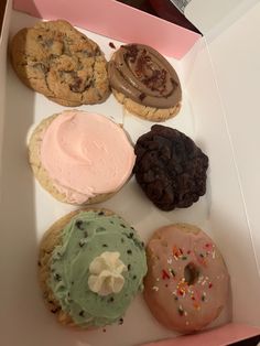 a box filled with assorted donuts and cookies on top of eachother