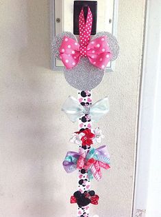 a door hanger with minnie mouse ears and bows hanging from it's side