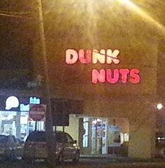 a neon sign that reads dunk nuts on the side of a building