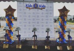 several construction hats and shovels are lined up in front of a backdrop for kids's day