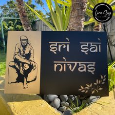 a sign with an image of a man sitting on a rock in front of a palm tree