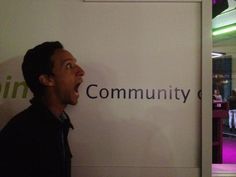 a man standing in front of a sign with his mouth open